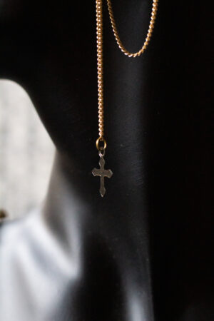 Detailaufnahme schwarze Büste mit Ohrring gold lange Kette und earcuff unten ein Kreuz