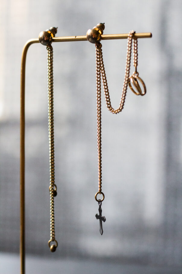 Detailaufnahme Ohrringpaar gold lange Kette und earcuff unten ein Kreuz