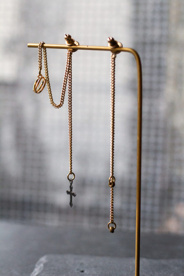 Detailaufnahme Ohrringpaar gold lange Kette und earcuff unten ein Kreuz