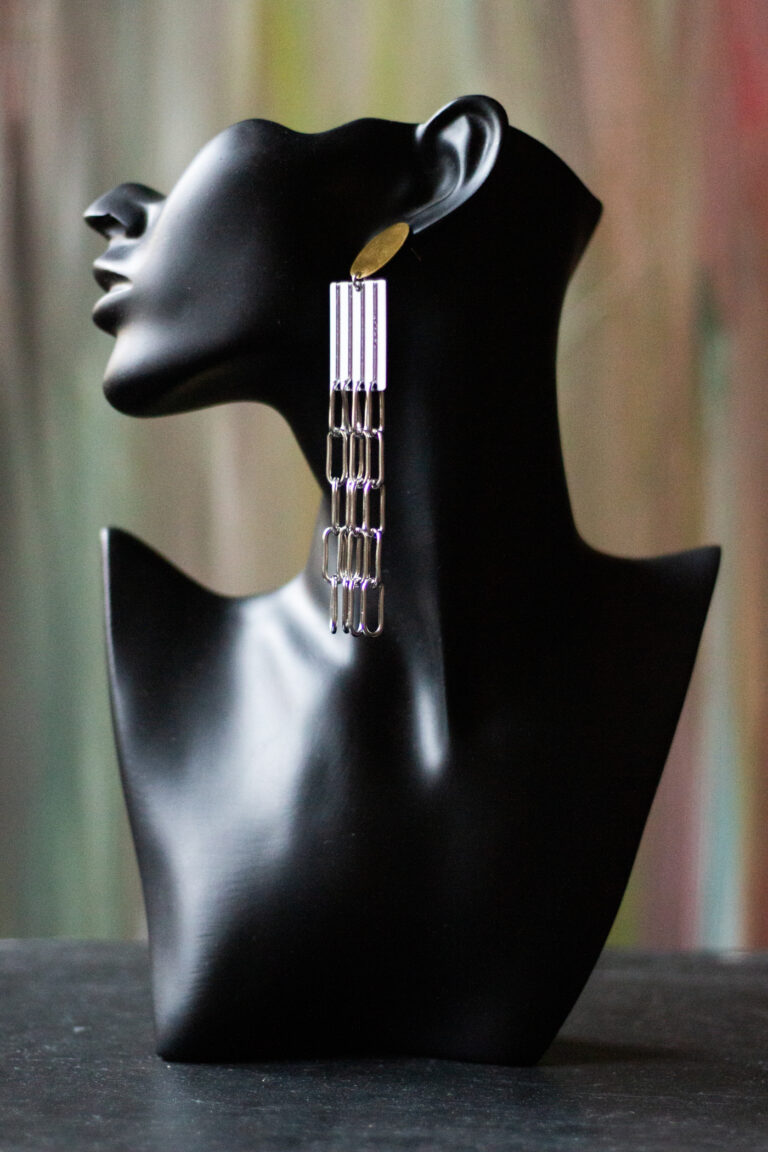 schwarze Büste mit Ohrring goldener Stecker, Acryl Mittelstück schwarz weiß, lange Edelstahl Gliederketten unten