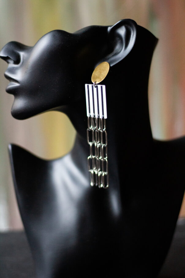 schwarze Büste mit Ohrring goldener Stecker, Acryl Mittelstück schwarz weiß, lange Edelstahl Gliederketten unten