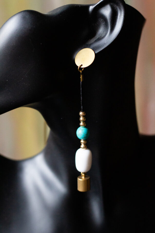 schwarze Büste mit Ohrring Messingstecker, Stoffband darunter kleine goldene Perlen, türkise und weiße Kugel