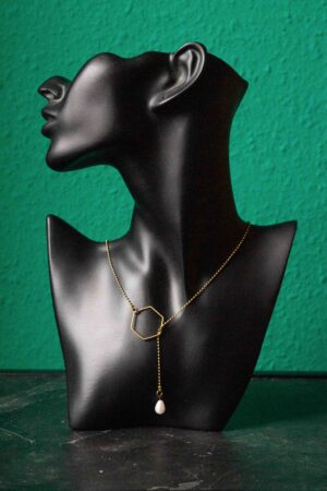 schwarze Büste mit Messing Wickelkette. 6 eckiges Mittelstück und Perle am Ende