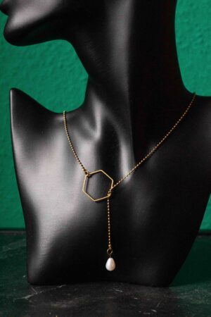Detailaufnahme schwarze Büste mit Messing Wickelkette. 6 eckiges Mittelstück und Perle am Ende