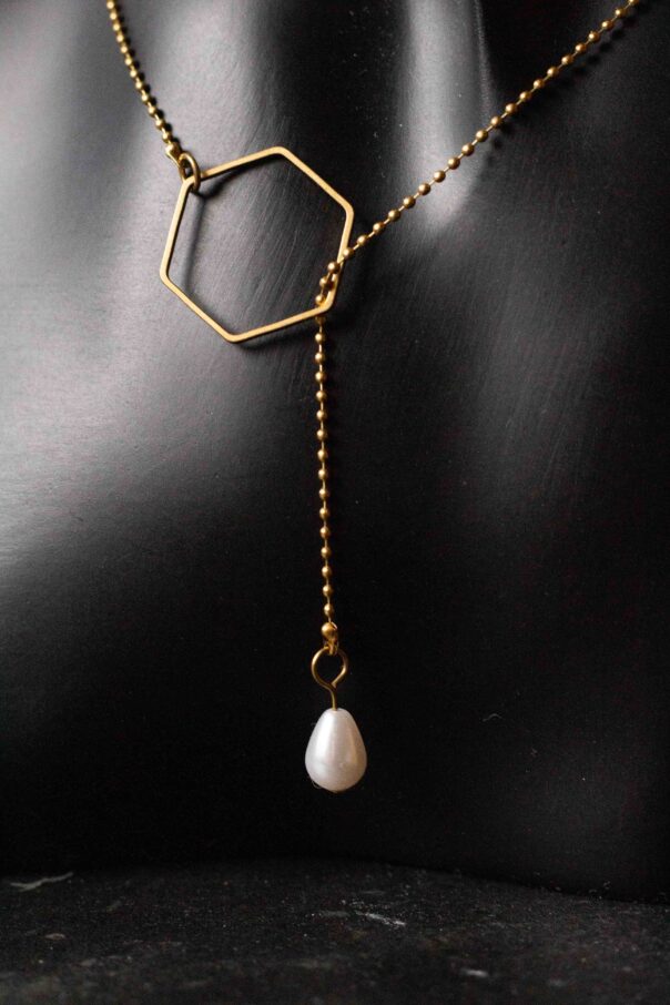 Detailaufnahme schwarze Büste mit Messing Wickelkette. 6 eckiges Mittelstück und Perle am Ende